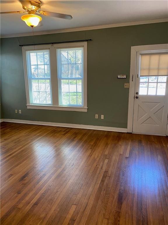 interior space featuring dark wood-style floors, baseboards, and crown molding