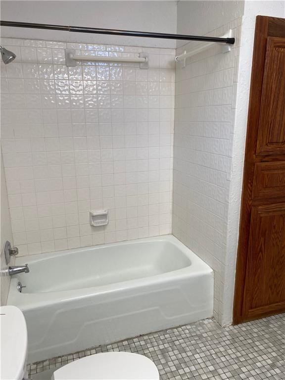 bathroom with toilet, tile patterned flooring, and washtub / shower combination