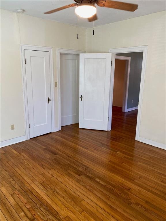 unfurnished bedroom featuring ceiling fan, baseboards, and wood finished floors