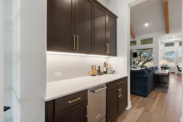 bar with light wood finished floors, recessed lighting, beam ceiling, and tasteful backsplash