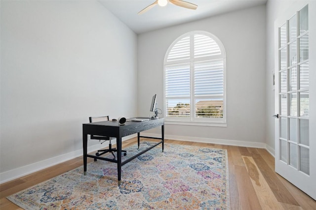 home office featuring baseboards, a ceiling fan, and wood finished floors