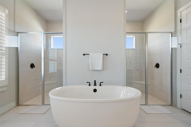 bathroom featuring a freestanding tub and a shower stall