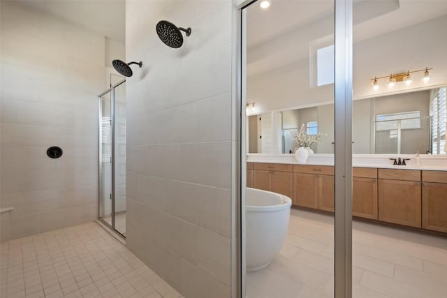 bathroom featuring tile patterned flooring, a freestanding tub, tiled shower, and vanity