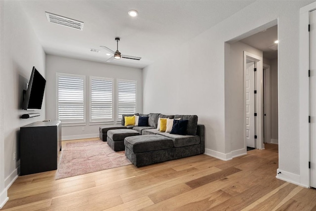 living area with a ceiling fan, visible vents, light wood-style flooring, and baseboards