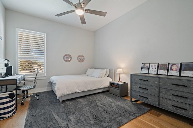 bedroom featuring ceiling fan, baseboards, and wood finished floors