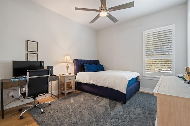 bedroom with wood finished floors, a ceiling fan, and baseboards