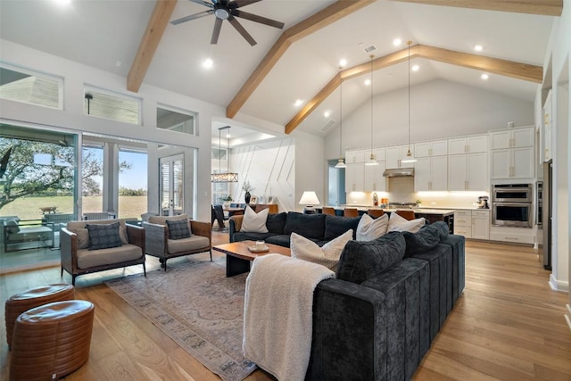 living area featuring visible vents, a ceiling fan, light wood-style flooring, beamed ceiling, and high vaulted ceiling