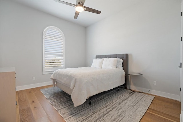 bedroom featuring baseboards, a ceiling fan, and light wood-style floors