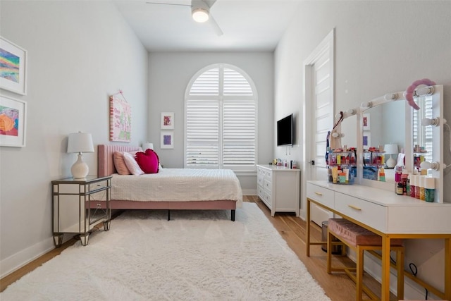 bedroom featuring light wood-type flooring, baseboards, and a ceiling fan