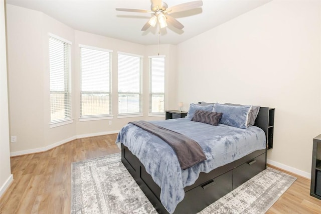 bedroom with wood finished floors, a ceiling fan, and baseboards