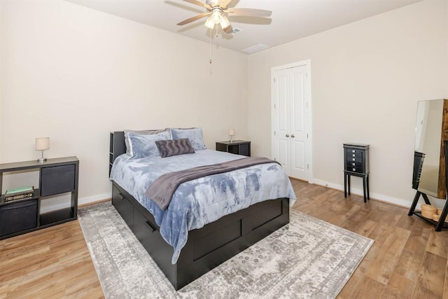 bedroom with ceiling fan, a closet, wood finished floors, and baseboards