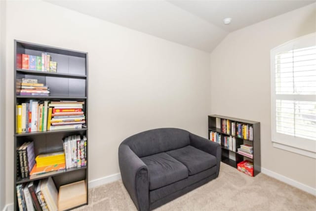 living area featuring carpet floors, baseboards, and vaulted ceiling