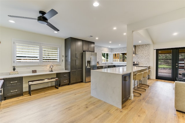 kitchen featuring stainless steel fridge, light wood-type flooring, and a healthy amount of sunlight