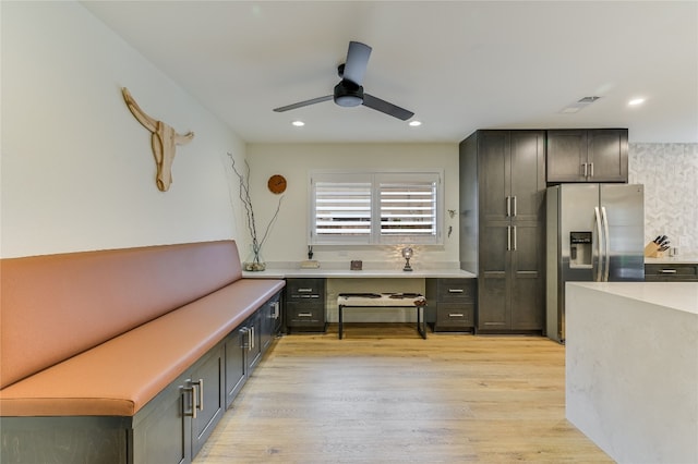 kitchen featuring a ceiling fan, visible vents, light wood-style flooring, stainless steel fridge with ice dispenser, and light countertops