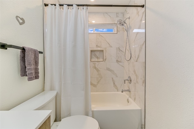 bathroom featuring vanity, toilet, a textured wall, and shower / bath combo