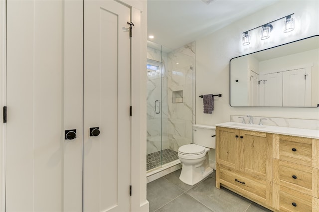 bathroom featuring vanity, toilet, tile patterned flooring, and a marble finish shower