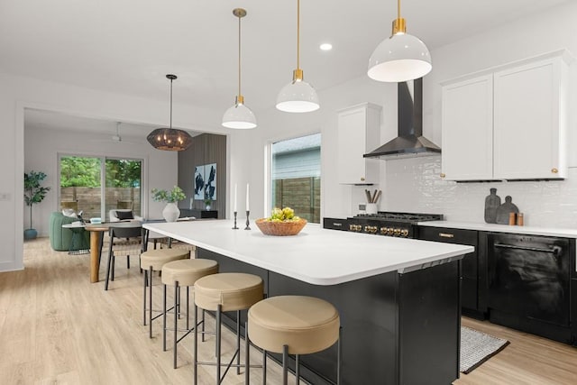 1912 Madison Ave, Austin, TX 78757 - kitchen featuring wall chimney exhaust hood, dishwasher, light wood-style flooring, light countertops, and recessed lighting