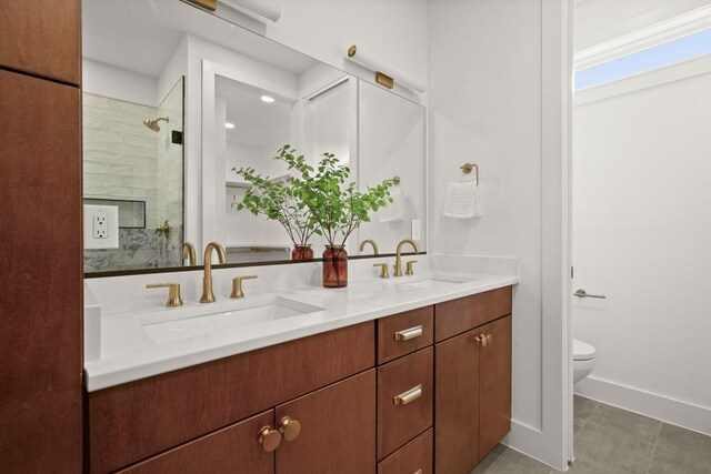 1912 Madison Ave, Austin, TX 78757 - full bathroom with double vanity, toilet, a tile shower, tile patterned flooring, and baseboards