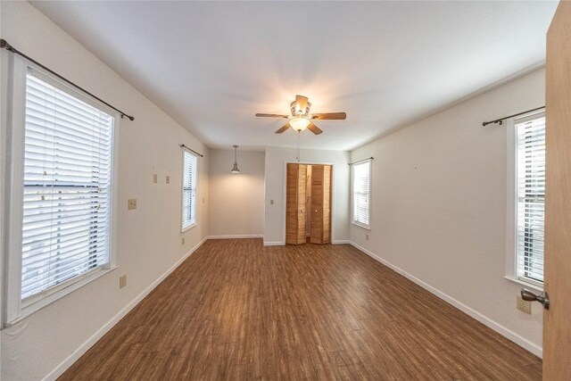 unfurnished room featuring ceiling fan, wood finished floors, and baseboards