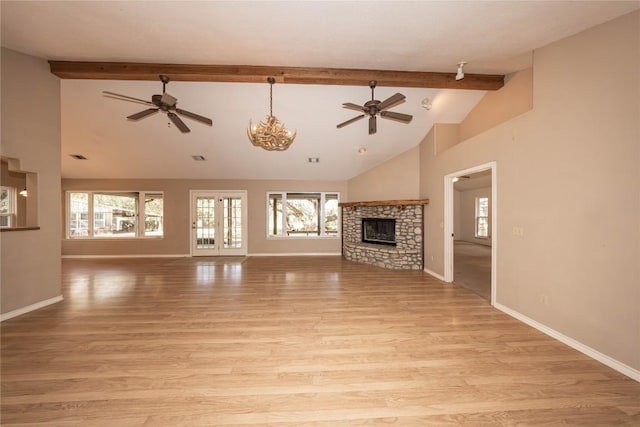 unfurnished living room featuring beamed ceiling, a fireplace, light wood-style flooring, and baseboards