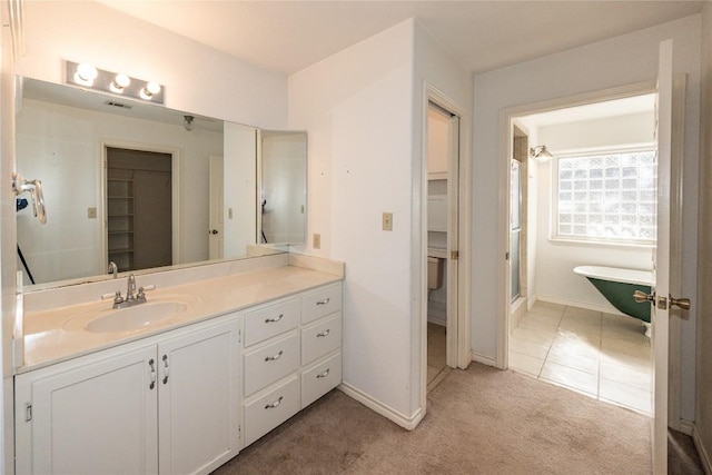 full bathroom with a shower with shower door, baseboards, a freestanding bath, and vanity