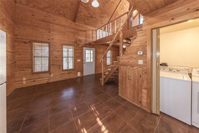 interior space with a healthy amount of sunlight, washing machine and dryer, and wooden walls