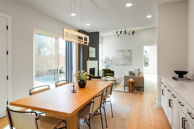 dining area with light wood finished floors, a fireplace, and recessed lighting