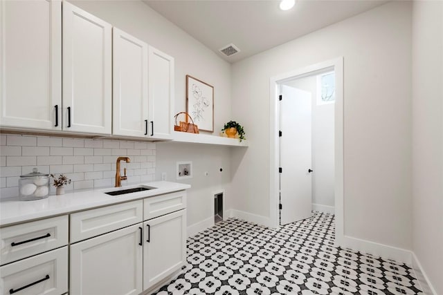 laundry area featuring hookup for a washing machine, hookup for a gas dryer, a sink, visible vents, and cabinet space