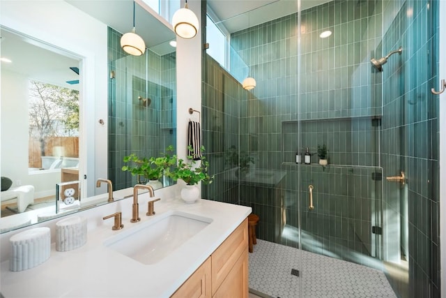 bathroom with a shower stall and vanity