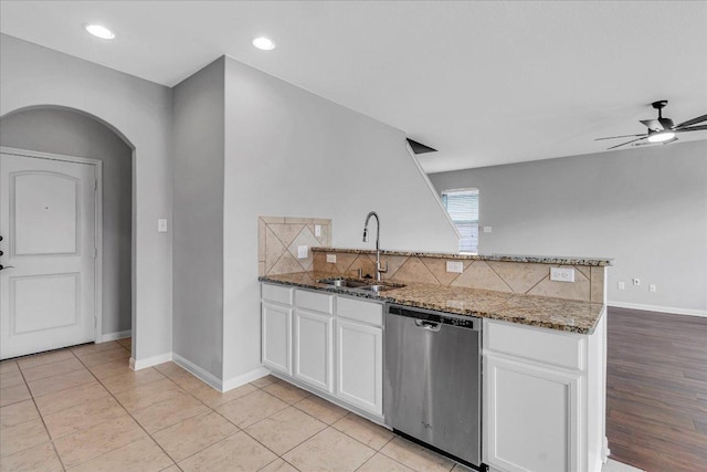 kitchen with dishwasher, a peninsula, tasteful backsplash, and a sink