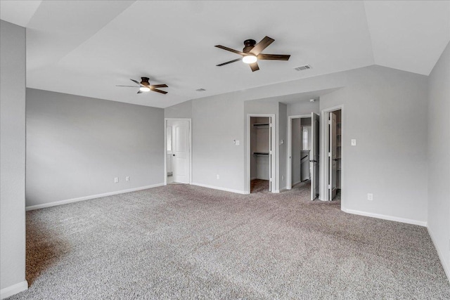 spare room featuring carpet, lofted ceiling, visible vents, ceiling fan, and baseboards