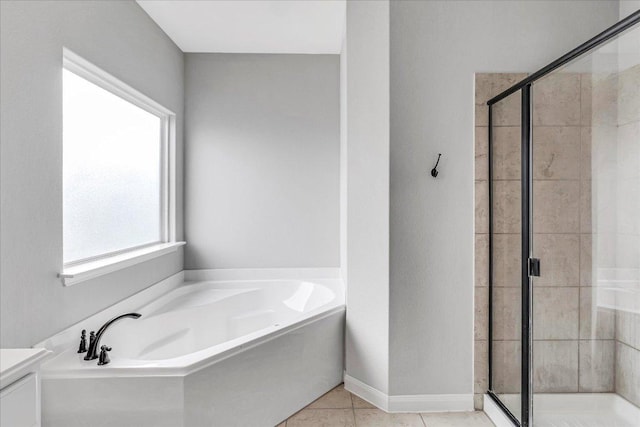 full bath featuring baseboards, a shower stall, a bath, and tile patterned floors