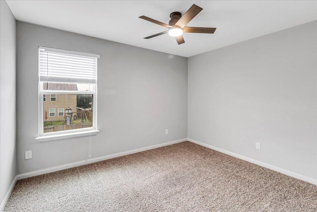 carpeted empty room featuring a ceiling fan and baseboards