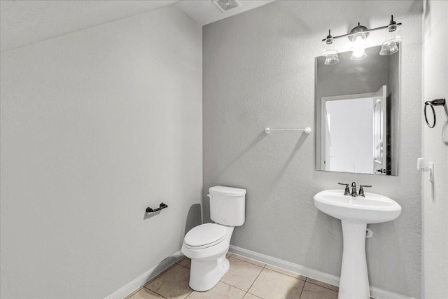 bathroom with baseboards, visible vents, toilet, and tile patterned floors