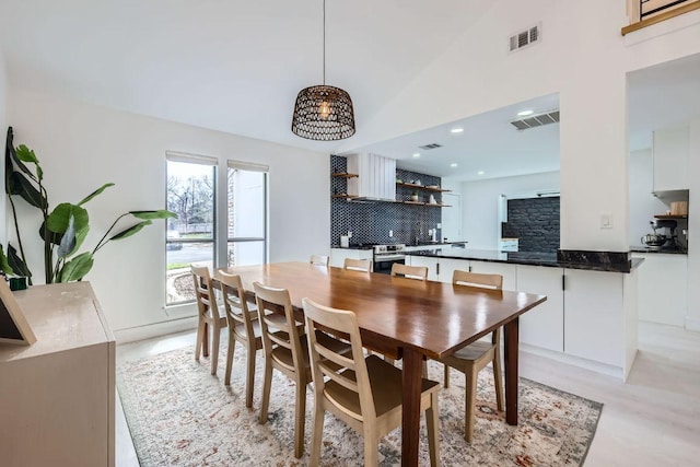 dining space featuring a towering ceiling and visible vents