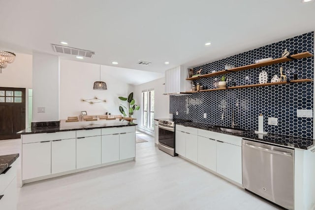 kitchen with appliances with stainless steel finishes, a sink, visible vents, and white cabinetry