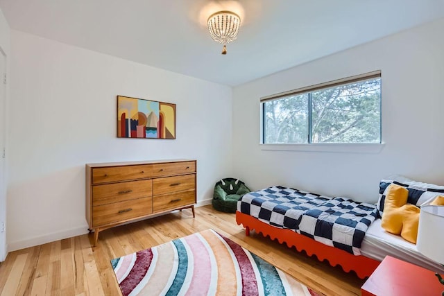 bedroom with light wood-type flooring and baseboards