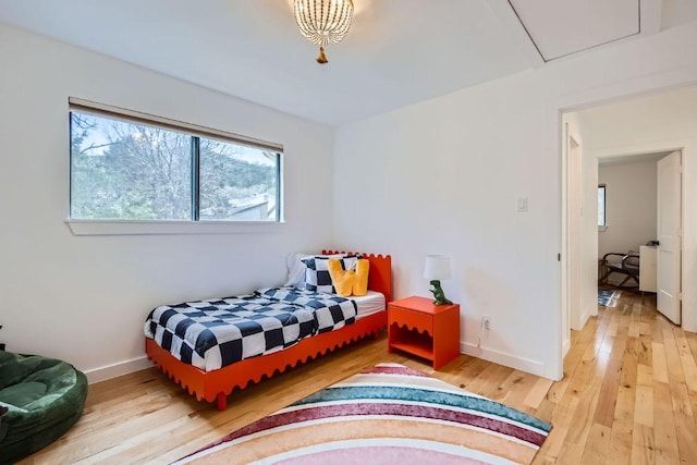 bedroom featuring light wood-style floors and baseboards