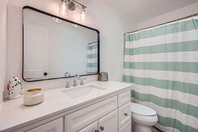 full bathroom featuring a shower with shower curtain, vanity, and toilet