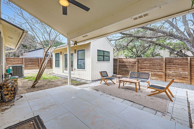 view of patio / terrace featuring central air condition unit, ceiling fan, visible vents, and a fenced backyard