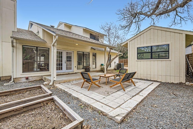 rear view of house with a vegetable garden, a patio, fence, cooling unit, and french doors