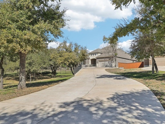 view of front of property featuring driveway and fence