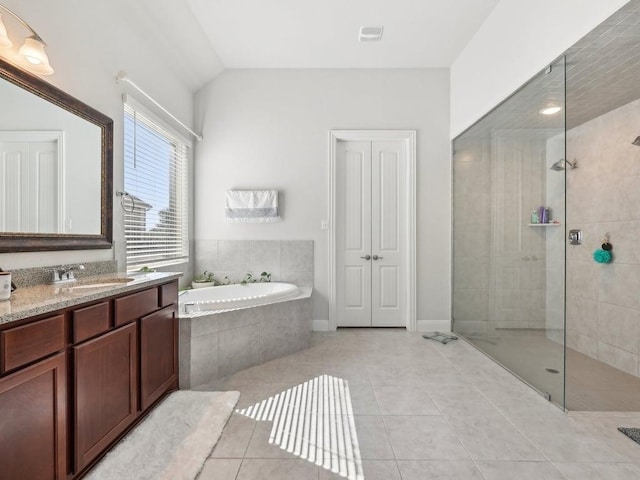 bathroom featuring a walk in shower, lofted ceiling, tile patterned flooring, vanity, and a bath