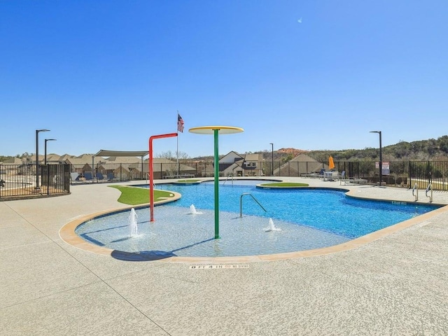 community pool with fence and a patio