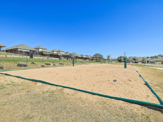 view of community featuring a residential view, fence, and volleyball court