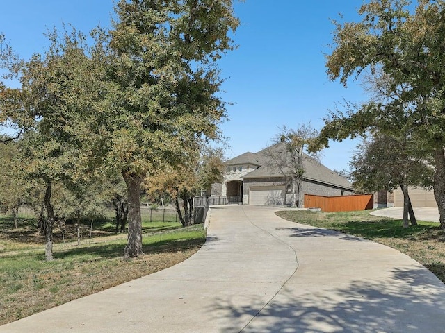 141 Bear Paw Run, Georgetown, TX 78628 - obstructed view of property featuring an attached garage, driveway, and fence