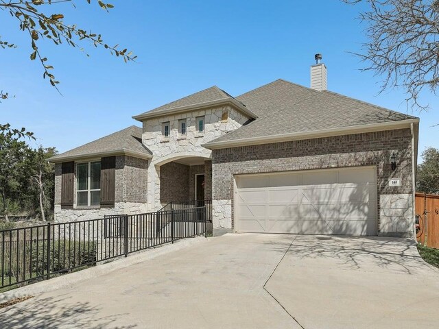 141 Bear Paw Run, Georgetown, TX 78628 - french country style house with stone siding, driveway, a garage, and fence