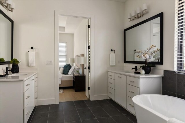 116 Azalea Loop, Horseshoe Bay, TX 78657 - ensuite bathroom with healthy amount of natural light, a soaking tub, tile patterned flooring, and two vanities