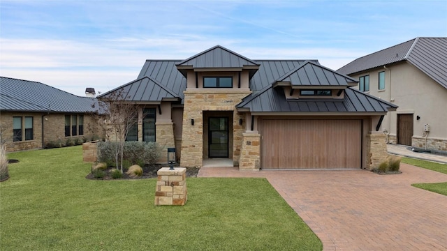 view of front facade with stone siding, metal roof, a standing seam roof, decorative driveway, and a front lawn