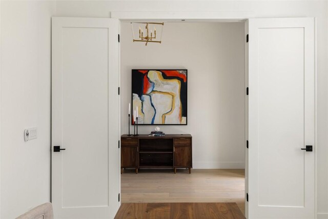 116 Azalea Loop, Horseshoe Bay, TX 78657 - hallway featuring wood finished floors, baseboards, and a chandelier